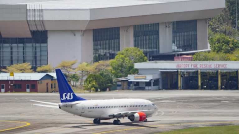 A Scandinavian Airlines plane lands on a Malaysian island, where the Norwegian king is being treated in hospital