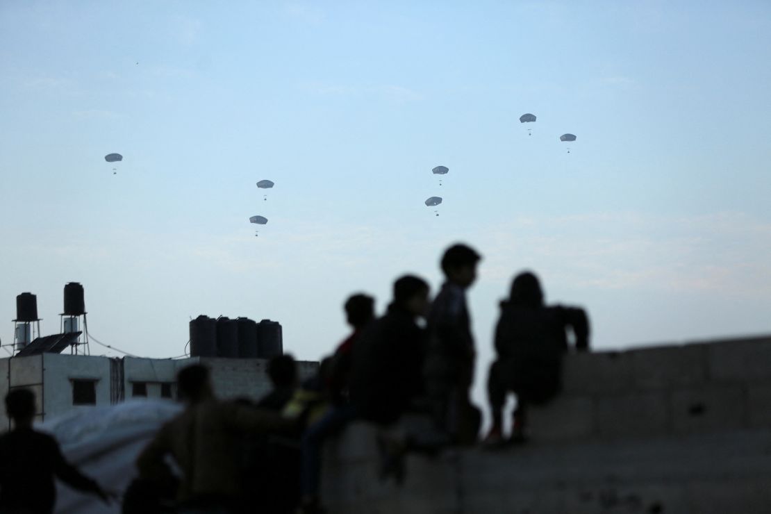 People watch the US military carry out its first aid drop into Gaza on March 2, 2024.