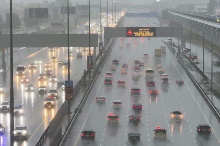 Vehicles drive through heavy rain on the Sheikh Zayed Expressway in Dubai, United Arab Emirates, Tuesday, April 16, 2024. Heavy rain hit the United Arab Emirates on Tuesday, submerging parts of major highways and leaving vehicles abandoned on roads across Dubai.  Meanwhile, the death toll in separate heavy floods in neighboring Oman has risen to 18 while others remain missing as the sultanate braces for the storm.  (AP Photo/Jon Gambrell)