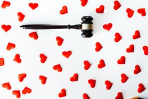 Gavel surrounded by red hearts, isolated on white, concept of the legal procedure for divorce.