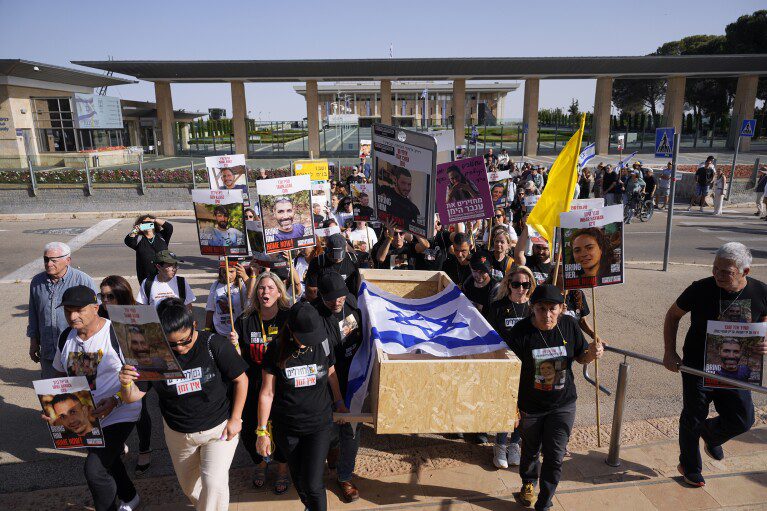 Family members and activists carry an empty coffin during a mock funeral held ahead of Israel's Remembrance Day for Israelis whose remains are being held by Hamas militants in the Gaza Strip, near the Israeli parliament building in Jerusalem, Thursday, May 9, 2024. Remembrance Day is always a somber occasion in Israel.  But in the wake of the events of October 7, the crisis took on a deep and harsh character of sadness coupled with rampant anger.  (AP Photo/Ohad Zwegenberg)