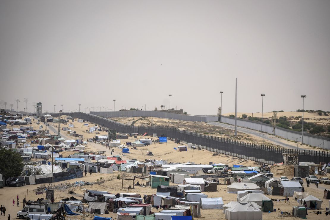 Palestinians displaced by the Israeli air and ground attack on the Gaza Strip walk through a makeshift camp in Rafah on the border with Egypt, in Gaza on May 10.