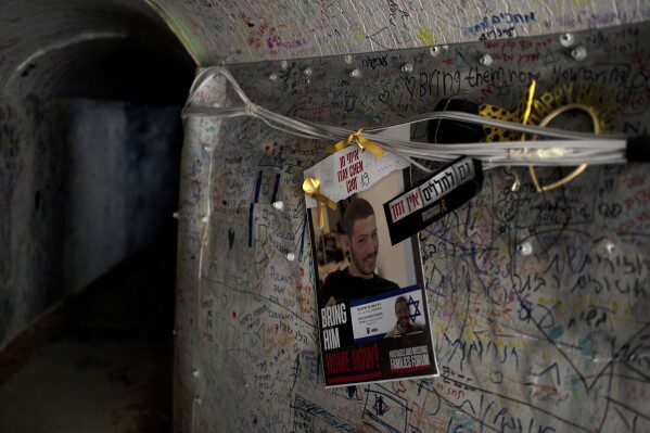 A poster depicting slain Israeli soldier Itai Chen hangs in a tunnel facility in the Gaza Strip, in Tel Aviv, Wednesday, May 8, 2024. Itai was killed in a Hamas attack on October 7, but unlike dozens of other families of soldiers killed that day, Chen's family has no grave to visit because their son's remains are being held in Gaza.  The absence of a final resting place is being felt acutely now, as Israel marks Remembrance Day for Fallen Soldiers, when cemeteries are filled with relatives weeping over the graves of their loved ones.  (AP Photo/Maya Aleruso)