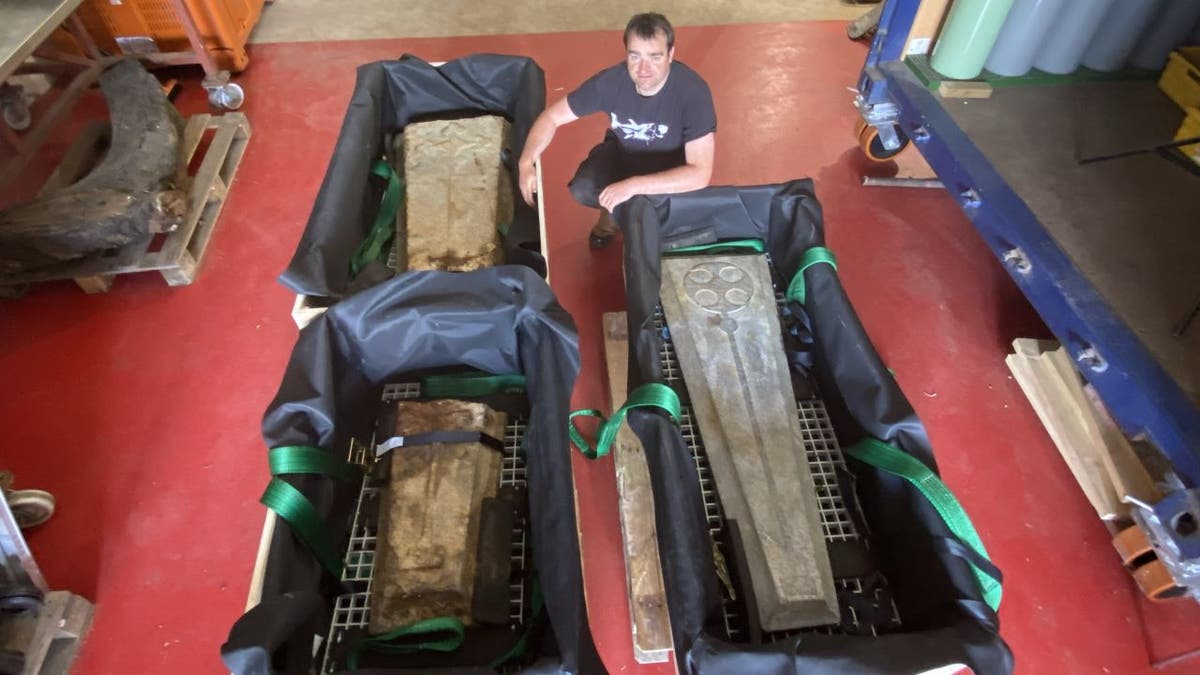 A man standing next to old boards