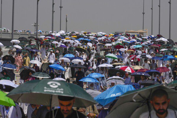 FILE - Muslim pilgrims use umbrellas to protect themselves from the sun as they arrive to throw stones at pillars in the symbolic stoning of the devil, the last ritual of the annual Hajj, in Mina, near the holy city of Mecca, Saudi Arabia, Tuesday, June 18, 2024. Sunday, June 23, 2024 More than 1,000 people died during this year's Hajj season in Saudi Arabia as believers faced extremely high temperatures in Islamic holy sites in the desert kingdom.  (AP Photo/Rafiq Maqbool)