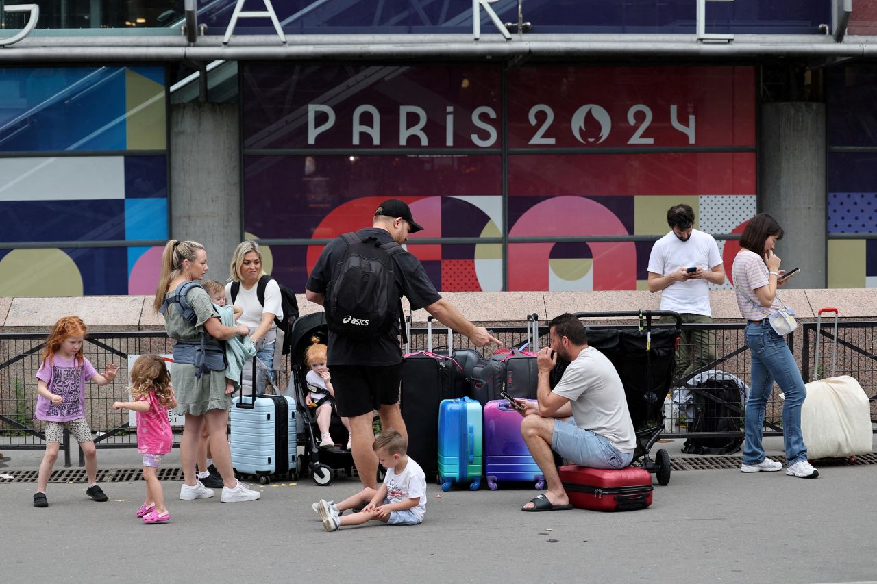 Travellers from Sydney, Australia, wait outside Montparnasse train station in Paris as they try to find other trains after their journey was disrupted by rail disruptions.