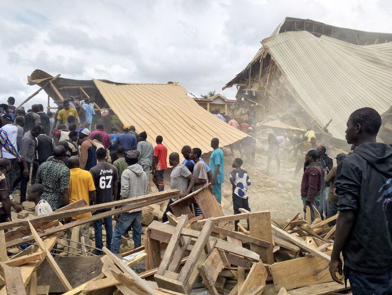 People stand near the ruins of a collapsed school building of Saint's Academy in Bosa Buji area, Plateau State, Nigeria [Joshua Inusa/Reuters]