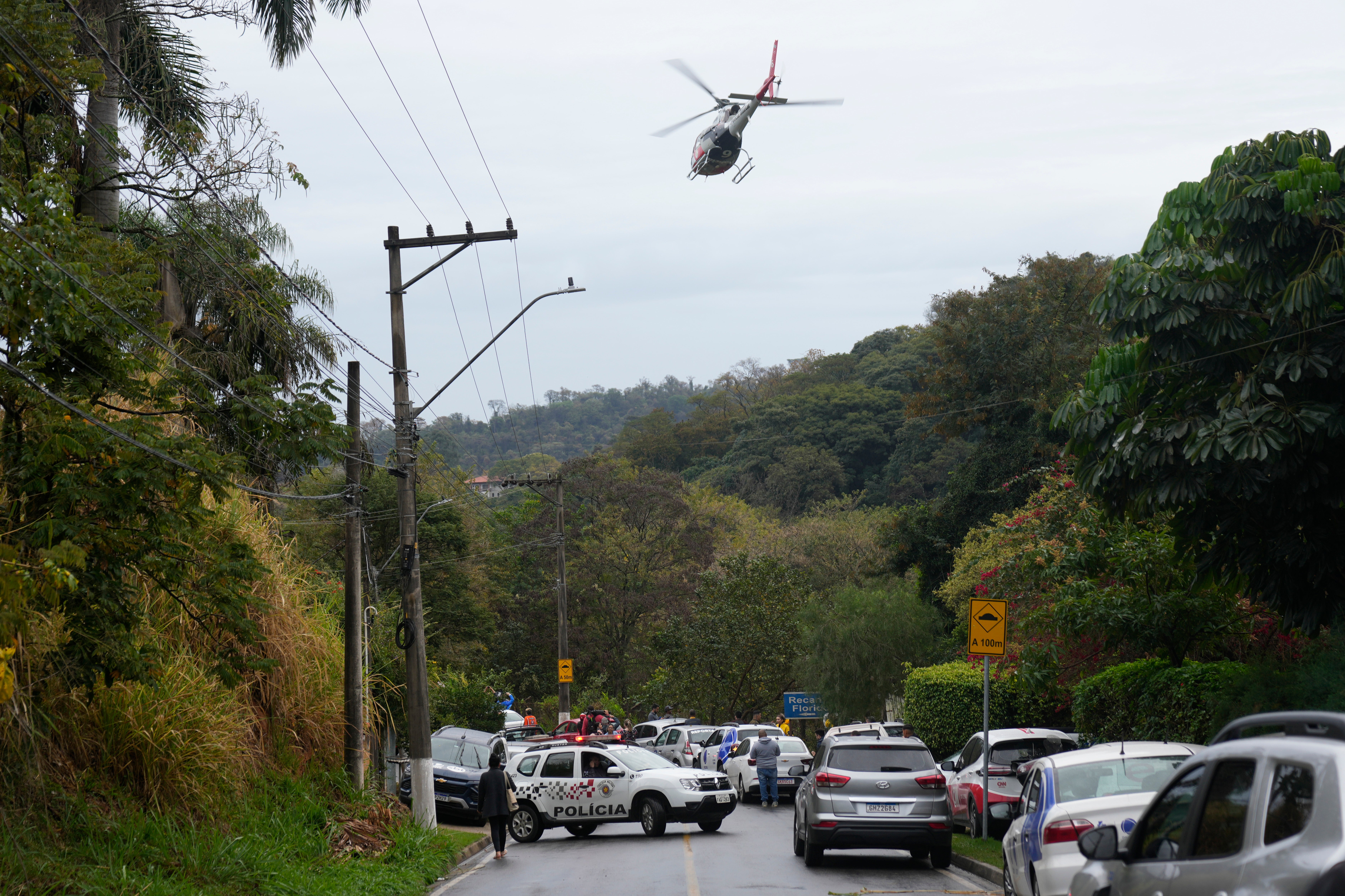 A helicopter flies over the neighborhood where Voyager Flight 2283 crashed Friday. Officials have not yet determined the cause of the crash.